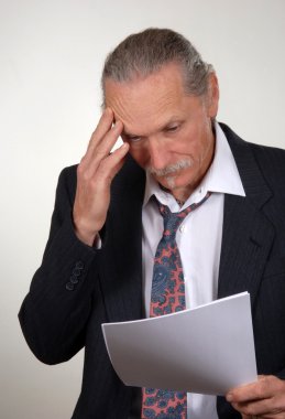 Stressed business man reviewing papers clipart