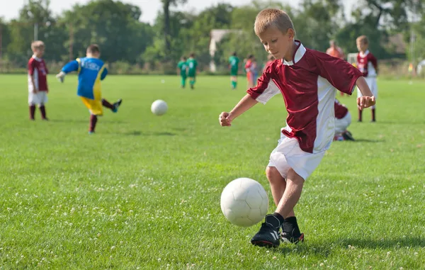 Boy kicking football — Stock Photo, Image