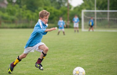 Little Boy playing soccer clipart