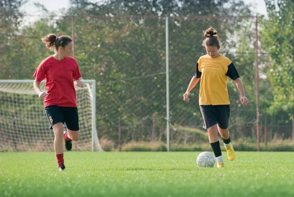 Tytöt pelaavat jalkapalloa — kuvapankkivalokuva