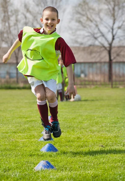 Çocuğun futbol sahası üzerinde atlama — Stok fotoğraf