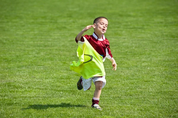 Счастливый мальчик на футбольном поле — стоковое фото