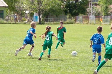 Children playing soccer clipart