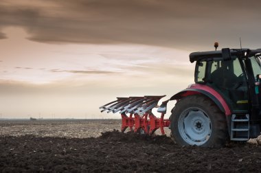 Plowing at dusk clipart