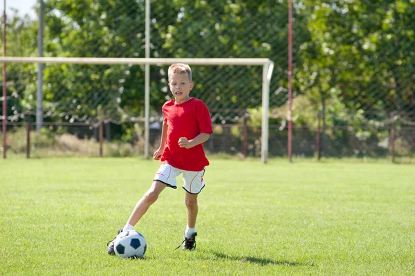 Niño jugando fútbol pelota — Foto de Stock