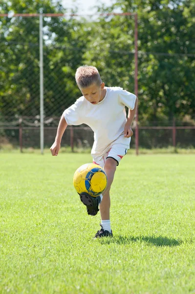Criança jogando bola de futebol — Fotografia de Stock