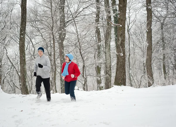 Famiglia che corre attraverso la neve — Foto Stock