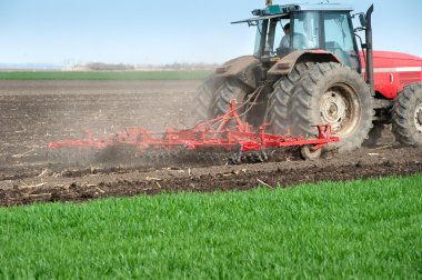 Tractor plowing the fields clipart