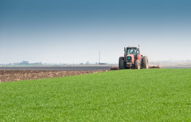 Tractor plowing the fields clipart