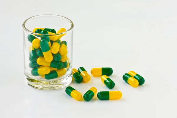 Pillole della capsula in un bicchiere — Foto Stock