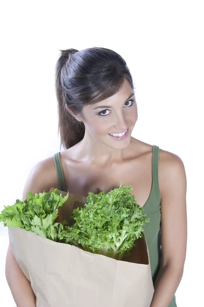 Young caucasian brunette hloding a bag of vegetables — Stock Photo, Image