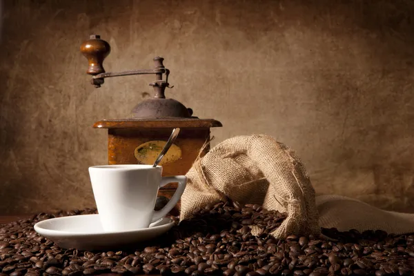 Vista horizontal de una taza de café espresso rodeada de granos de cofee y —  Fotos de Stock