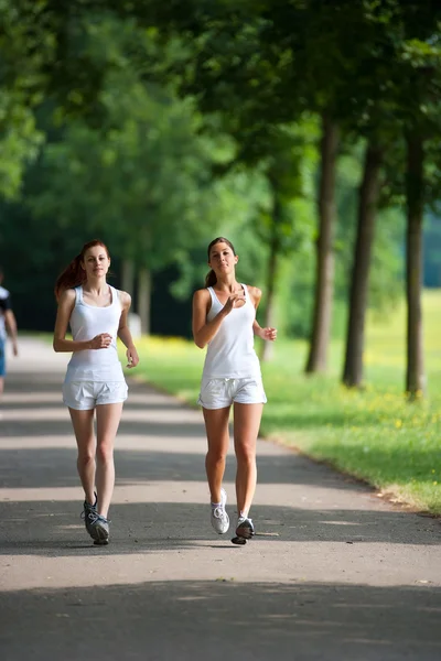 Twee jonge vrouw uitgevoerd in een park — Stockfoto