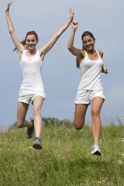 Two young woman running in a park — Stock Photo, Image