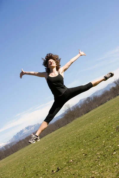 Jonge vrouw sprong in een park — Stockfoto