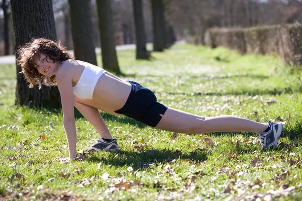 Jonge vrouw doen steeds activiteit in een park — Stockfoto