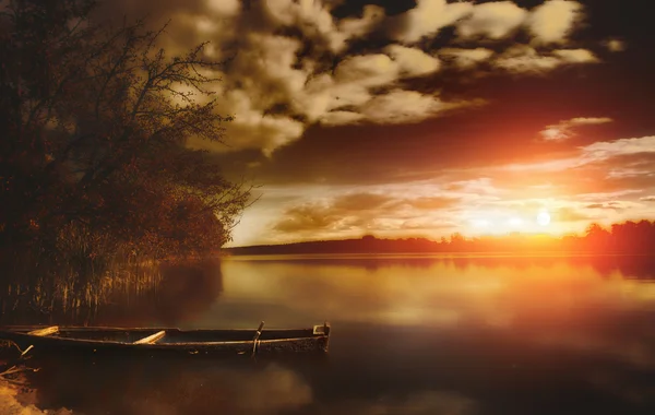 stock image Fishing boat on calm lake during vibrant Summer sunset