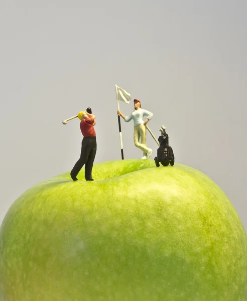Миниатюрный гольф на яблоке — стоковое фото