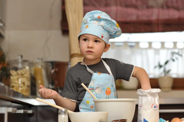 Kleiner Junge Koch backt Kuchen Stockbild