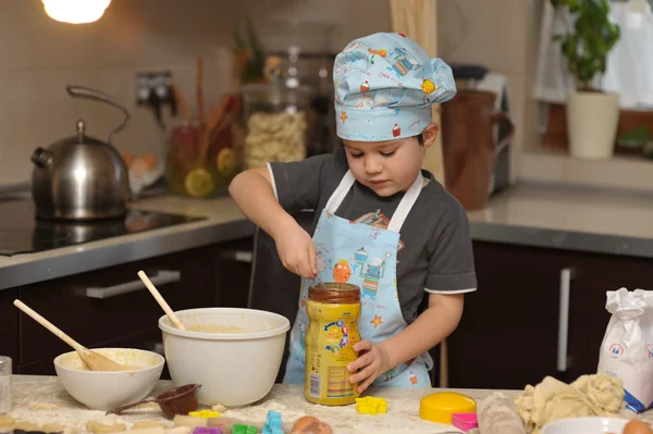Kleiner Junge Koch backt Kuchen Stockfoto