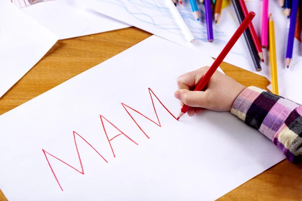 La mano del bambino sta scrivendo MAMA — Foto Stock