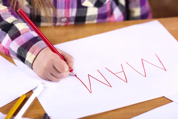 Child's hand is writing MAMA — Stock Photo, Image