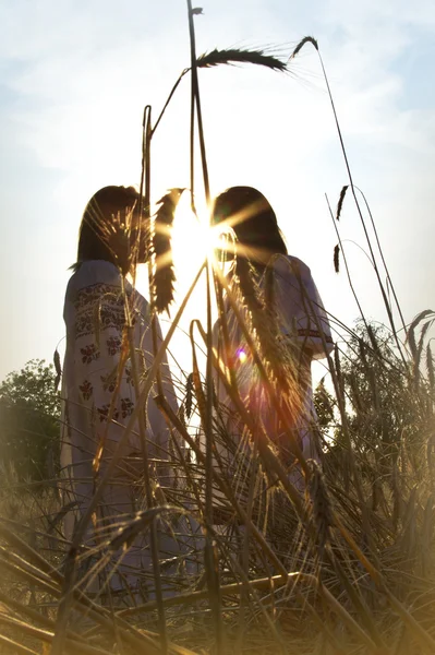Two girls standing at sunset — Stock Photo, Image