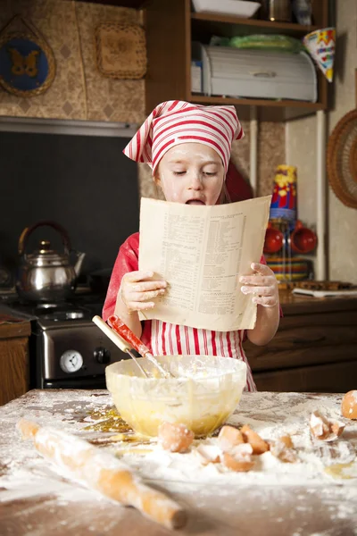 Pequeño chef en la cocina con delantal y pañuelo en la cabeza —  Fotos de Stock