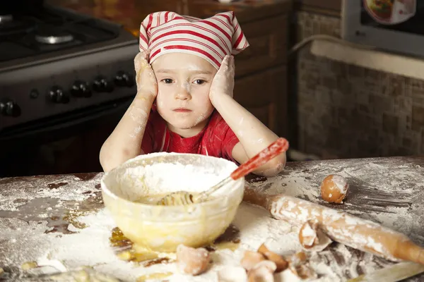 Little chef in the kitchen wearing an apron and headscarf — Stock Photo, Image
