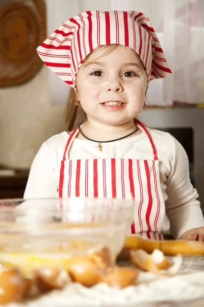 Pequeño chef en la cocina con delantal y pañuelo en la cabeza —  Fotos de Stock