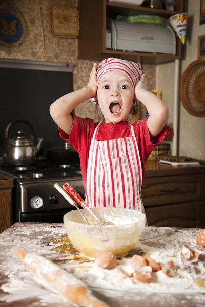Lilla kocken i köket bär ett förkläde och huvudduk — Stockfoto