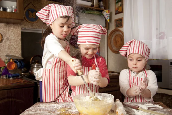 Три маленьких повара наслаждаются на кухне, устраивая большой беспорядок. Литт — стоковое фото