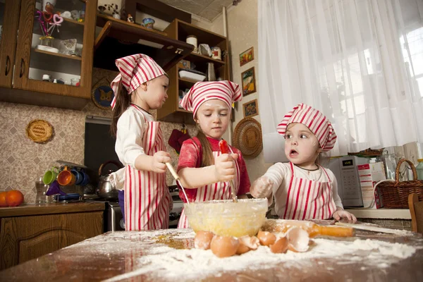Drei kleine Köche genießen in der Küche das große Durcheinander. litt — Stockfoto