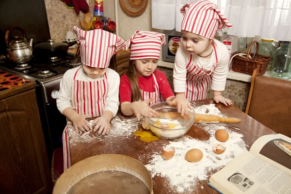 Tres pequeños chefs disfrutando en la cocina haciendo un gran lío. Litt. —  Fotos de Stock