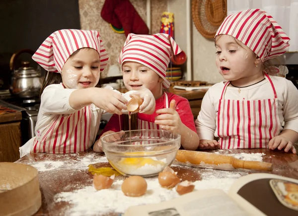 Tres pequeños chefs disfrutando en la cocina haciendo un gran lío. Litt. —  Fotos de Stock