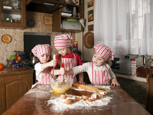 Três pequenos chefs desfrutando na cozinha fazendo uma grande bagunça. Litt... — Fotografia de Stock
