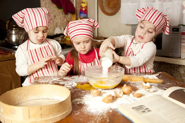 Drie kleine koks genieten in de keuken maken van grote puinhoop. Litt — Stockfoto