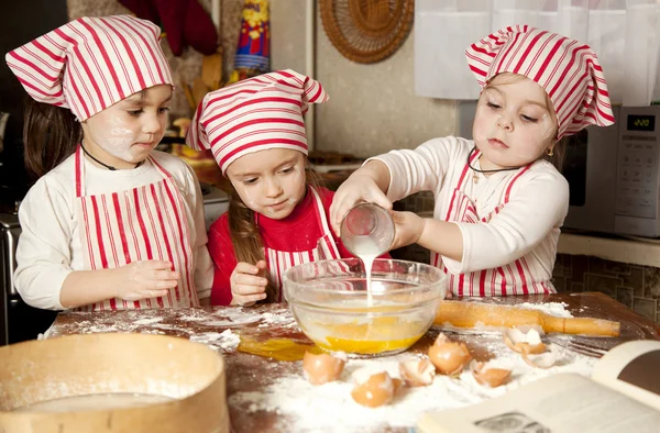 Drie kleine koks genieten in de keuken maken van grote puinhoop. Litt — Stockfoto