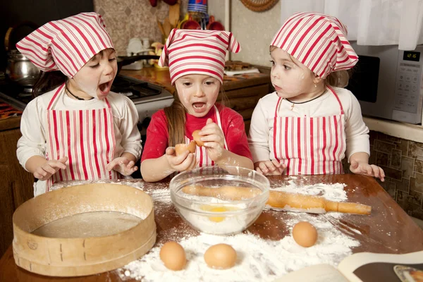 Három kis szakácsok élvezi a nagy rendetlenség konyhában. Litt Jogdíjmentes Stock Képek