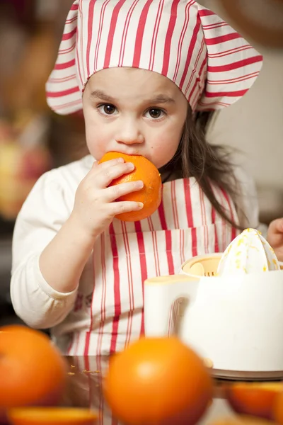 Маленькая девочка делает свежий и здоровый апельсиновый сок — стоковое фото