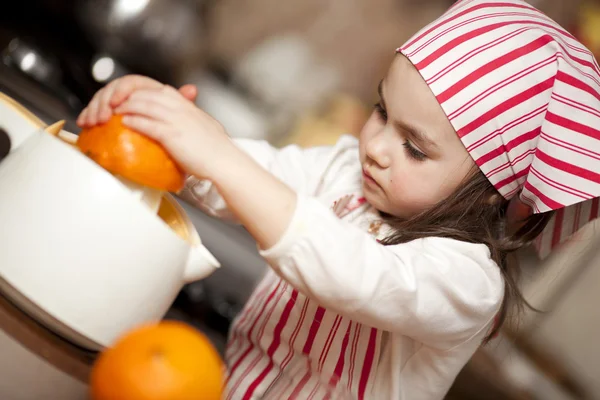 制作新鲜和健康的桔子汁的小女孩 — 图库照片
