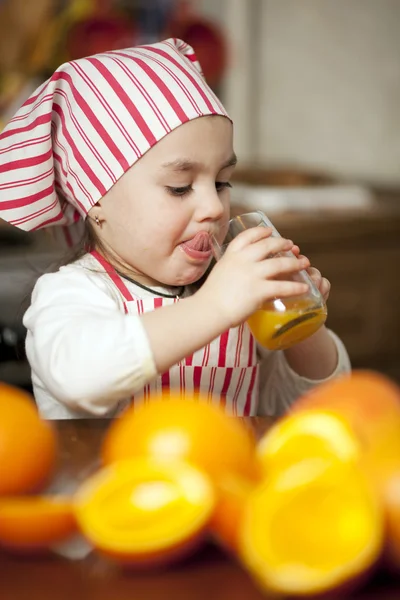 Lilla flickan att göra friska apelsinjuice — Stockfoto