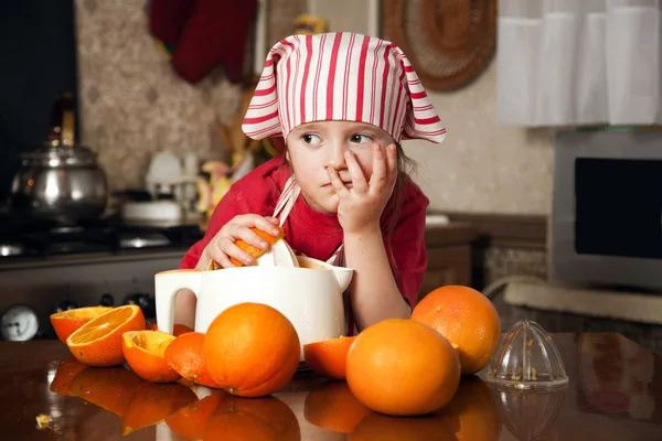 Lilla flickan att göra friska apelsinjuice — Stockfoto