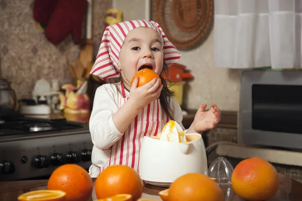 Маленькая девочка делает свежий и здоровый апельсиновый сок — стоковое фото