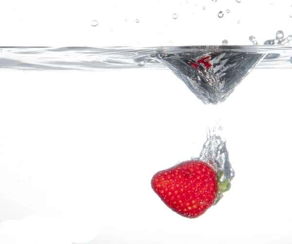 Erdbeeren, die ins Wasser spritzen — Stockfoto