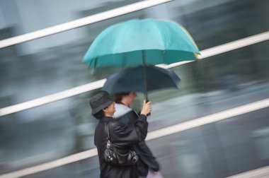 Two women under umbrella in rain clipart