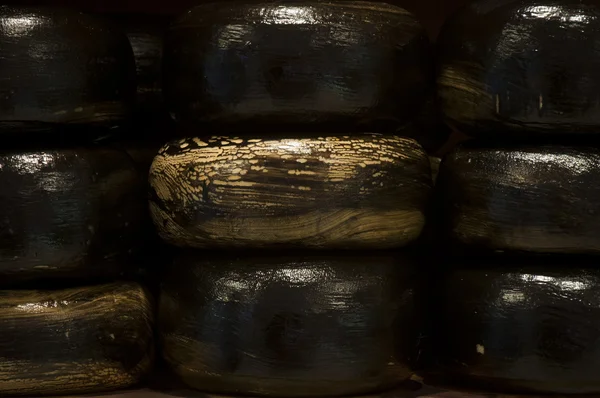 Devět velkých černých sýr gouda — Stock fotografie