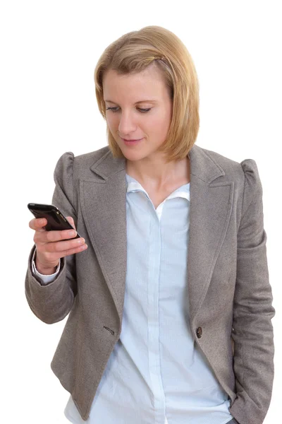 Young female executive reading text message on her mobile phone and smiling — Stock Photo, Image
