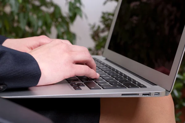 Femme d'affaires assise et travaillant avec un ordinateur portable sur ses genoux — Photo