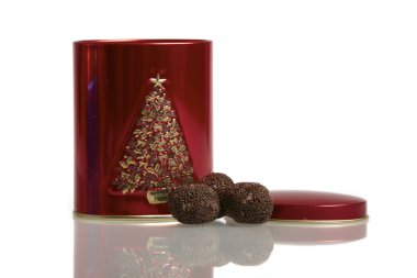 A red metal box with three rum balls on white background clipart